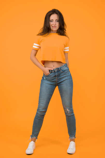 Beauty and make up. Pretty girl with long hair. Fashion and style. Skinny jeans suits her. Self confidence is best outfit. Sexy girl yellow background. Sexi girl. Sensual girl in casual style. - 写真・画像