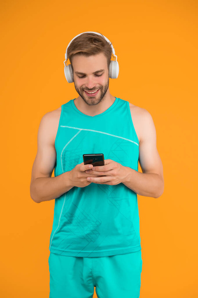 Application for trainings with online couch. Athletic man listen music smartphone. Workout playlist. Sport and fitness. Active lifestyle. Health and wellness. Workout motivation. Tracking progress. - Fotografie, Obrázek
