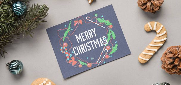 Greeting card with text MERRY CHRISTMAS and decorations on grey background - Zdjęcie, obraz