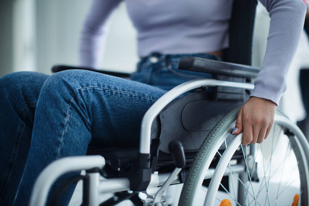 Close-up of young woman at wheelchair in a hospital. - Photo, image