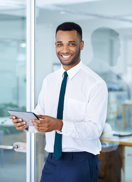 Nuestros números se ven muy bien. Un joven hombre de negocios afroamericano guapo usando su tableta digital mientras está en la oficina - Foto, imagen