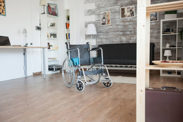Αναπηρική καρέκλα σε γηροκομείο για ασθενείς με ειδικές ανάγκες. Δεν υπάρχουν άνθρωποι στο δωμάτιο στο ιδιωτικό γηροκομείο. Κινητικότητα θεραπείας υποστήριξη ηλικιωμένων και ατόμων με αναπηρία βάδισμα αναπηρία ανάρρωση παράλυση - Φωτογραφία, εικόνα