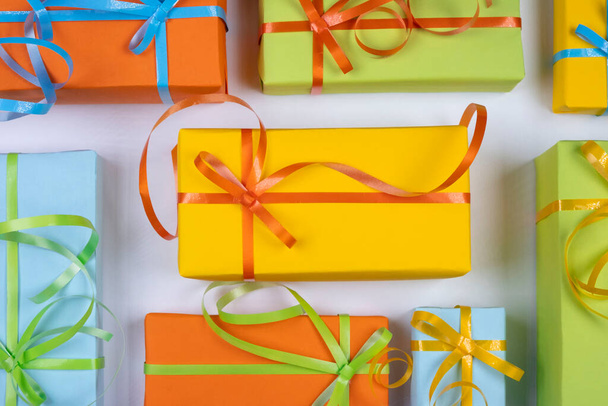 φόντο με κουτιά δώρων διακοπών σε διάφορα χρώματα με κορδέλες και φιόγκους ή δώρα σε λευκό φόντο, το νέο έτος, τα Χριστούγεννα ή τις διακοπές έννοια.  - Φωτογραφία, εικόνα