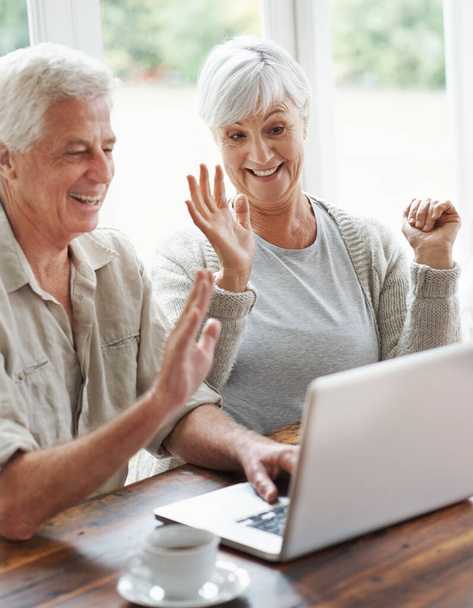 It feels like youre right here with us. A cheerful senior couple having a video chat on a laptop - Photo, Image