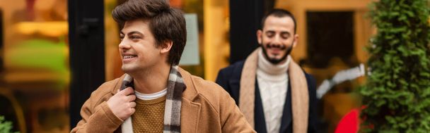 happy and stylish gay man looking away near boyfriend on blurred background, banner - Foto, Imagem