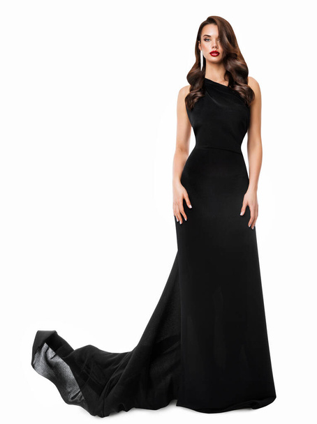 Fashion Woman in Black Long Dress. Beautiful Model in Evening Gown with Train over White Background. Elegant Lady with Holiday Wavy Hair style and Glamour Makeup - Photo, Image