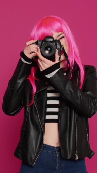 垂直ビデオ:写真を撮るためにデバイスを使用して、写真家としてdslrカメラで作業し、楽しい魅力的なクールな女の子。楽しい女性は気楽で、画像をキャプチャします,写真セッション. - 映像、動画