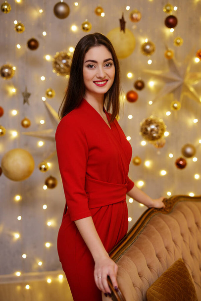 Jeune femme souriante en costume rouge dans les décorations de Noël - Photo, image