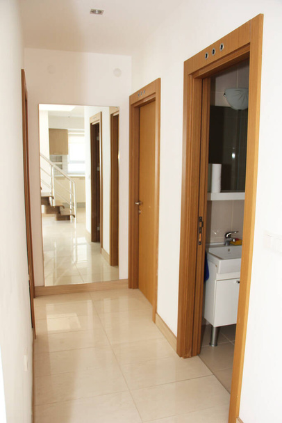 diseño interior del pasillo en el apartamento con paredes blancas y puertas marrones - Foto, Imagen