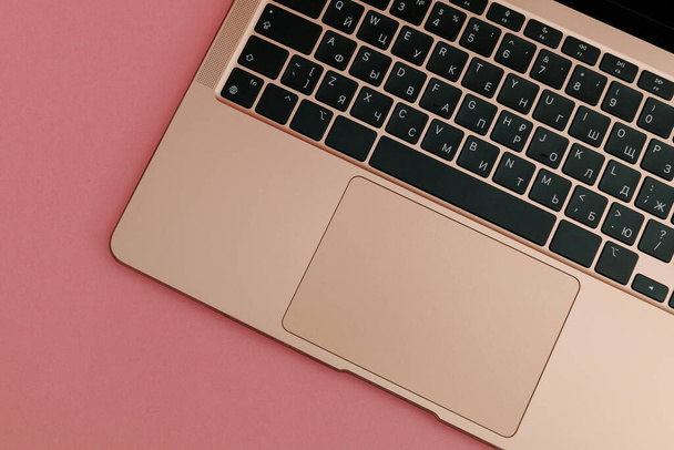 Χρυσό φορητό υπολογιστή σε ροζ φόντο - Φωτογραφία, εικόνα