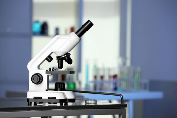 Modern medical microscope on metal table in laboratory, space for text - Foto, imagen