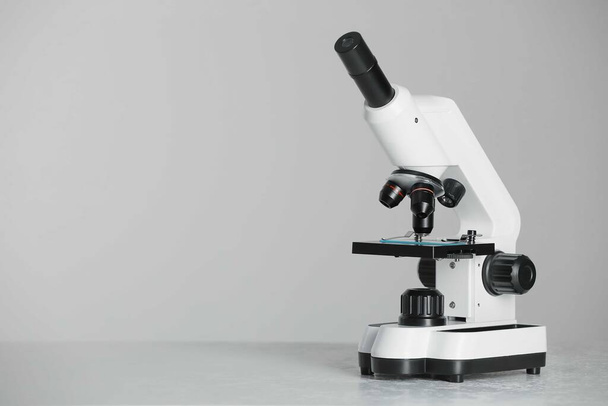 Modern microscope on grey background. Space for text - Fotoğraf, Görsel