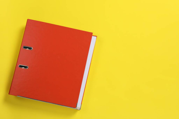 Red office folder on yellow background, top view, Space for text - Zdjęcie, obraz