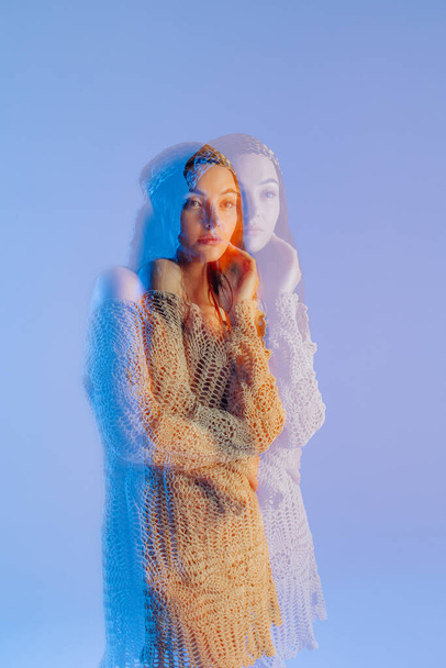 Young woman poses in knitted lacy dress and bandana against blue background. Image with multi exposure artistic effect. - Foto, Imagem
