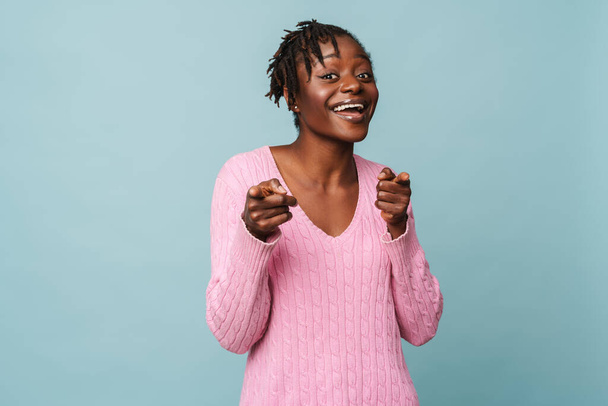 African american happy woman smiling and pointing at camera isolated over blue background - Foto, Imagem