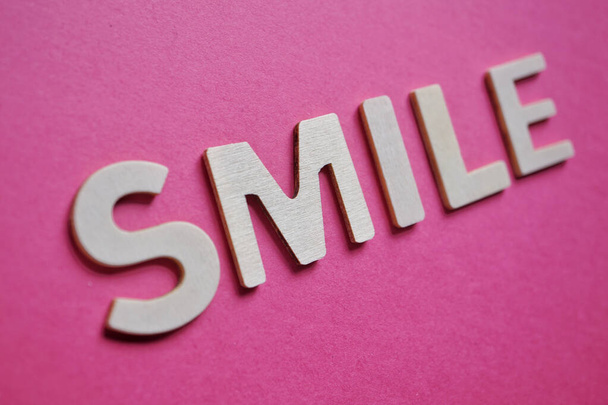 Lächeln Wort auf dem rosa Hintergrund, Gefühle und Emotionen  - Foto, Bild