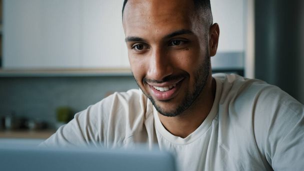Ön cephedeki Afrikalı çok ırklı adam bilgisayarlı daktilo kullanarak evde bilgisayarla sohbet ederek uzaktan kumandalı internet uygulaması alışverişi e-ticaret web sitesi - Fotoğraf, Görsel