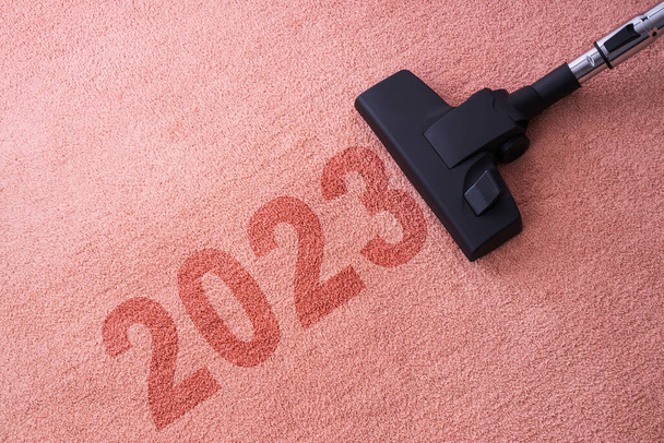 2023 Limpeza de casa de Ano Novo com aspirador de pó e espaço de cópia para um texto - Foto, Imagem