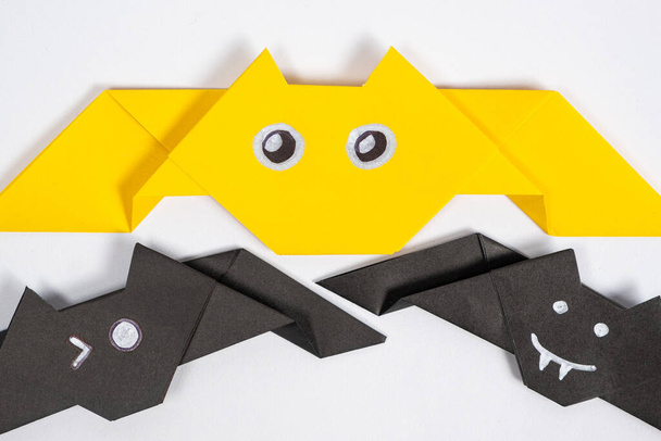 Murciélagos de Halloween, origami manualidades de papel de bricolaje sobre fondo blanco, vista superior. - Foto, imagen