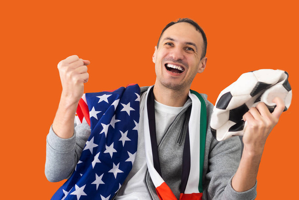 mužský fotbalový fanoušek se zmačkanou koulí a s vlajkou SAE a USA. - Fotografie, Obrázek