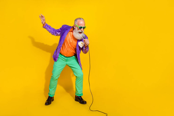 Full length photo of attractive funny man wear purple velvet jacket enjoying karaoke empty space isolated yellow color background. - Fotoğraf, Görsel