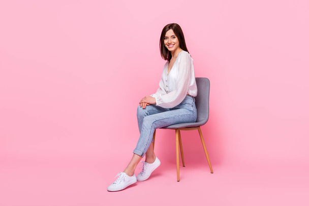 Full length photo of good looking office worker sit stool posing empty space wear stylish outfit isolated pink color background. - Foto, afbeelding