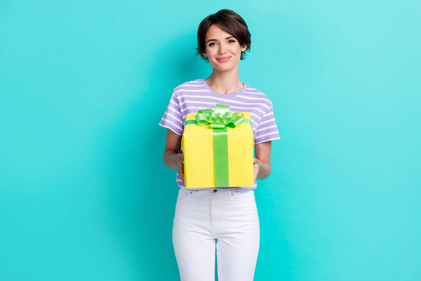 Portrait of pretty cheerful gorgeous girl with bob hairstyle wear striped t-shirt give you present isolated on turquoise color background. - 写真・画像