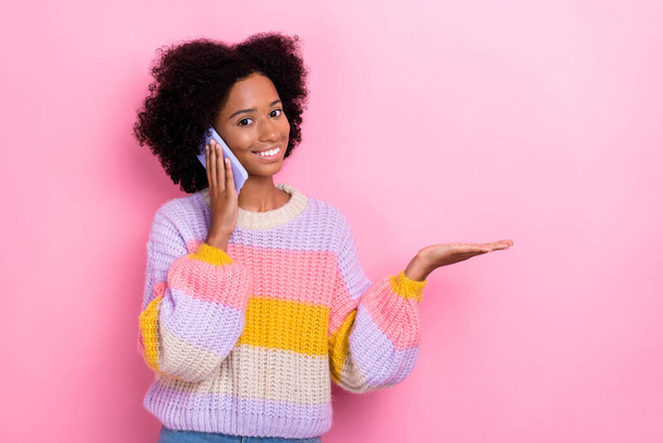 Photo of positive cheerful girl perming coiffure knit sweater talking phone demonstrate empty space isolated on pink color background. - Foto, Imagem