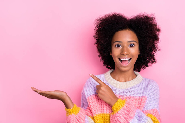 Portrait of impressed excited girl wavy hairstyle knit sweatshirt demonstrating empty space open mouth isolated on pink color background. - Fotografie, Obrázek