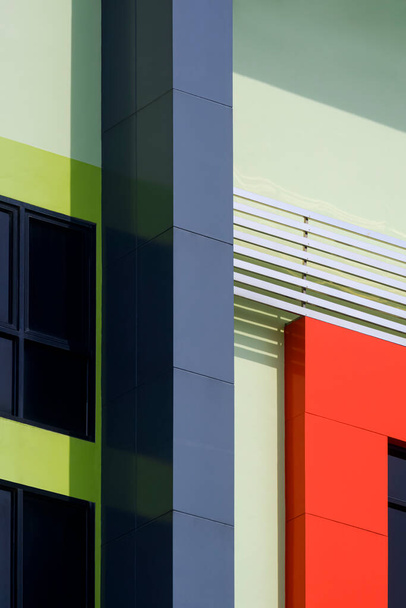 Геометрический рисунок фона из цветной алюминиевой композитной плитки из нержавеющей стали и стеклянных окон на внешней современной отделке стен здания - Фото, изображение