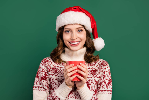 Portrait of pretty cheerful girl hands hold fresh coffee mug toothy smile isolated on green color background. - 写真・画像
