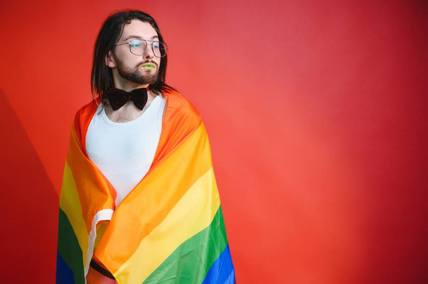 Gay man hold rainbow striped flag isolated on colored background studio portrait. People lifestyle fashion lgbtq concept. - Foto, Bild