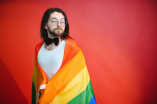 Gay man hold rainbow striped flag isolated on colored background studio portrait. People lifestyle fashion lgbtq concept. - Fotografie, Obrázek