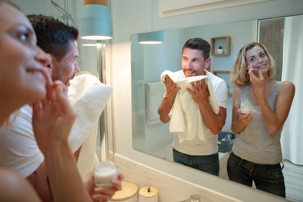 woman and man applying cream in bathroom - Φωτογραφία, εικόνα