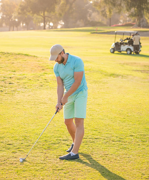 męski golfista na profesjonalnym polu z zieloną trawą słoneczna pogoda, sport. - Zdjęcie, obraz