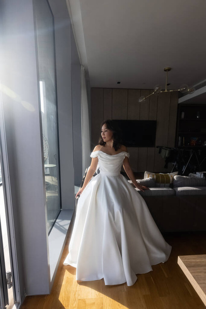 Luxury bride in white dress posing while preparing for the wedding ceremony. High quality photo - Фото, изображение