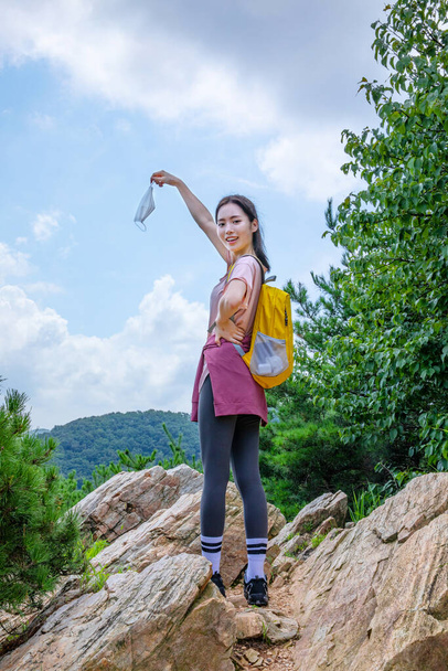 korean young hiker woman holding in hand protective mask - Foto, imagen
