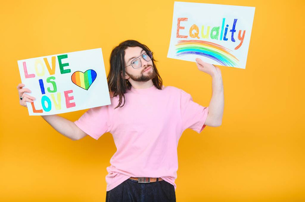 Hands of gay man holding lgbt banner on rainbow flag background lgbt symbol. - Fotó, kép