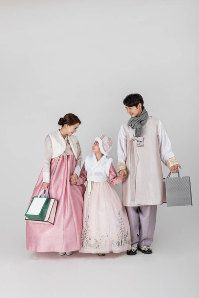 Korean family in Hanbok, against white studio white background - Foto, imagen