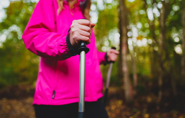 Woman with trekking sticks. Nordic walking. - Zdjęcie, obraz