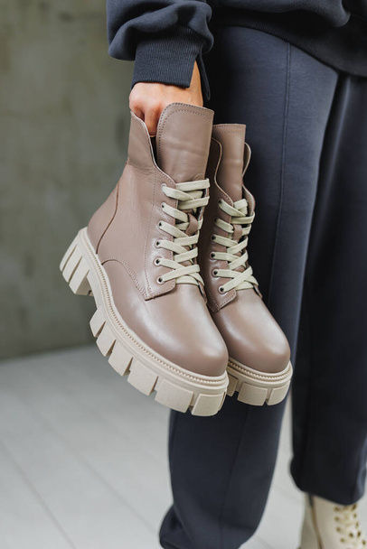 Beige boots on women's feet. Winter beige leather women's shoes. Collection of warm shoes for women - Foto, afbeelding