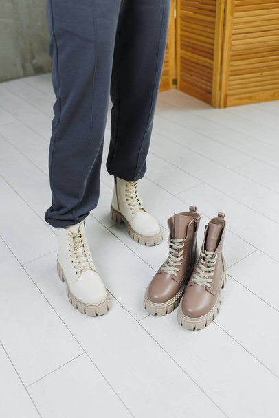 Beige boots on women's feet. Winter beige leather women's shoes. Collection of warm shoes for women - Photo, Image
