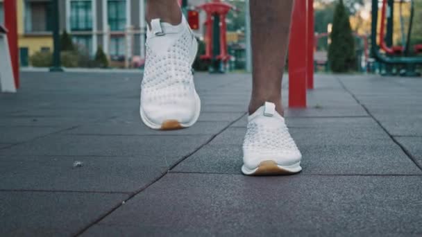 Közelkép lábak férfi sportoló fehér trendi tornacipőben professzionális sport cipő futó helyszínen fiatal kocogó készen áll a futás triatlon kocogás verseny maraton fitness kardió kitartás gyakorlása - Felvétel, videó