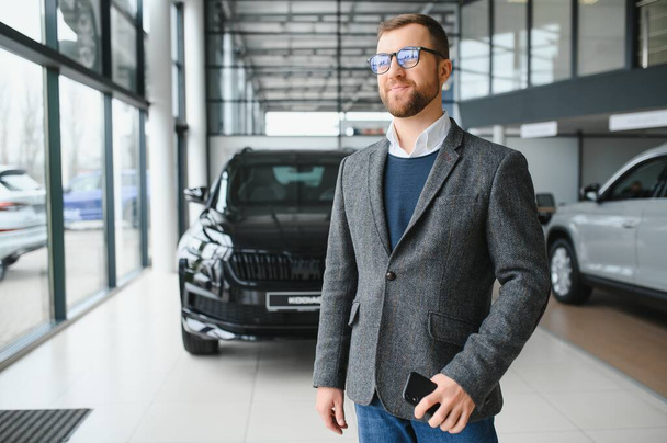 Man minded customer male buyer client in suit choose auto to go look aside want buy new automobile in car showroom - Fotografie, Obrázek
