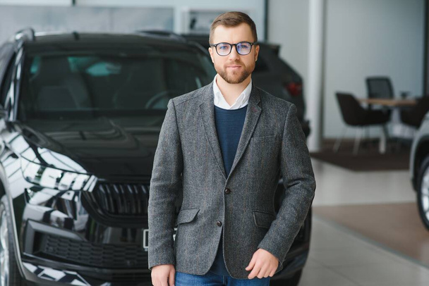 Man minded customer male buyer client in suit choose auto to go look aside want buy new automobile in car showroom - Fotografie, Obrázek