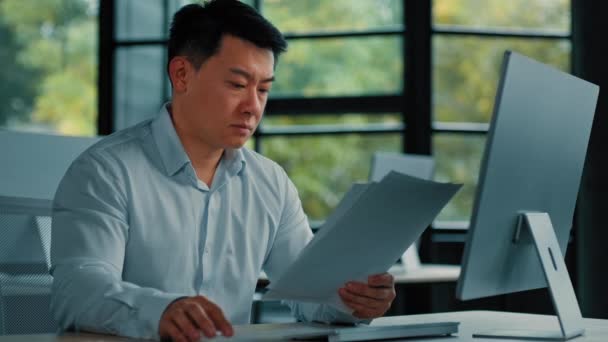 Epätoivoinen surullinen aasialainen japanilainen vanhempi asiantuntija liikemies istuu toimistossa lue asiakirjoja huijaus ilmoitus virhe liiketoiminnan dokumentaatio mies tutkimus paperityötä virheelliset tiedot järkyttynyt velkaongelmasta - Materiaali, video