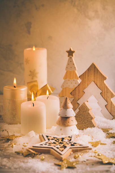 Різдвяна прикраса зі свічками та дерев'яними ялинками в золотому тоні
 - Фото, зображення