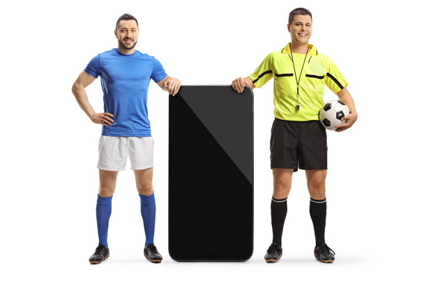 Referee and a football player leaning on a smartphone isolated on white background - Фото, зображення
