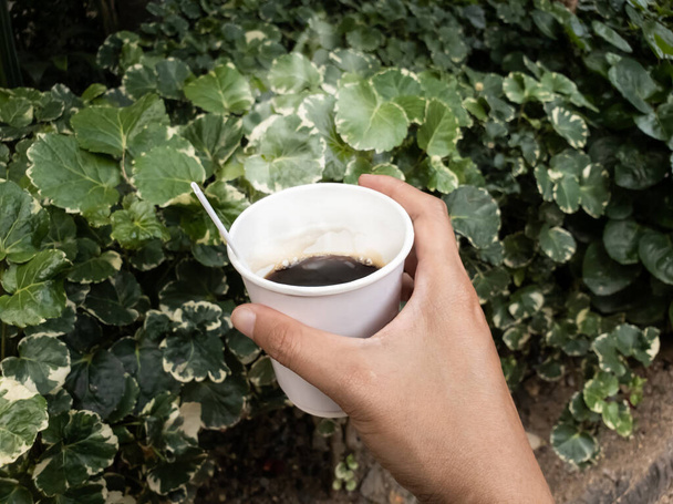 Hand holding hot of coffee cup lifestyle of eating and drinking coffee outside - Photo, Image