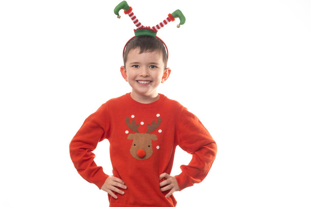 Sehr entzückender kleiner Junge mit Weihnachtsmann-Pyjama hat viel Spaß im Fotostudio auf isoliertem weißem Hintergrund. - Foto, Bild